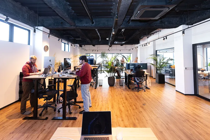 An overview of the office, with people using standing desks