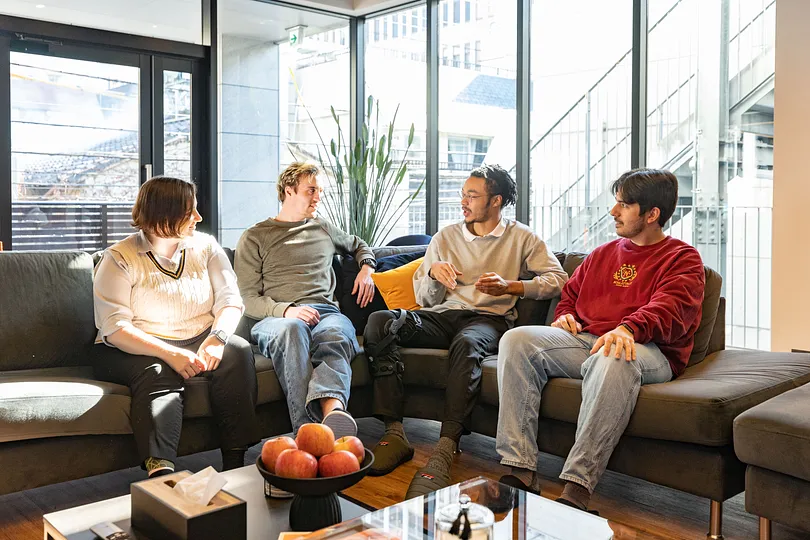 Four people sitting on a sofa
