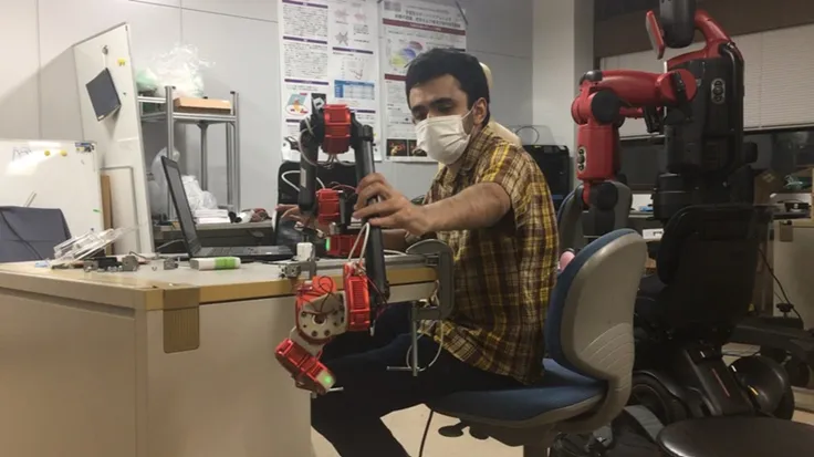 Abdul working with robotic equipment in a his university lab.